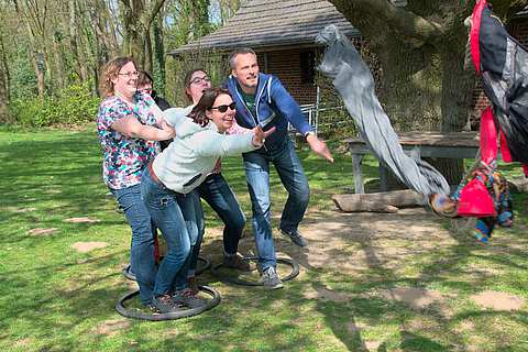 Teambuilding mit mehreren Teilnehmern die ein Seil schwingen | mit GeccoTours-TeamEvents.com