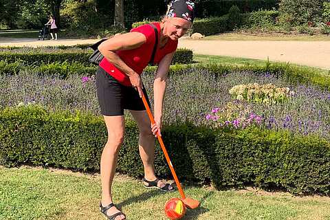 Eine Frau mit einem Lederball und einem Bauerngolfen Schlaeger bei der TeamChallenge | mit GeccoTours-TeamEvents.com